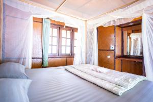 利邦岛利邦海滩度假酒店的一间卧室配有一张带天蓬的白色床