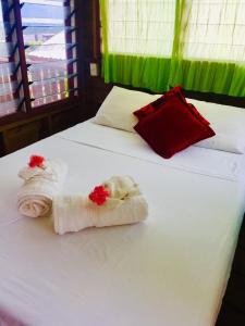 阿皮亚阿坡拉高地休息室宿加早餐旅馆的白色的床,带毛巾和红色枕头
