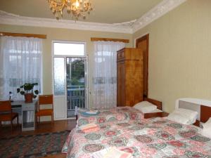 库塔伊西Friends House的一间卧室配有一张床、一张书桌和一个窗户。