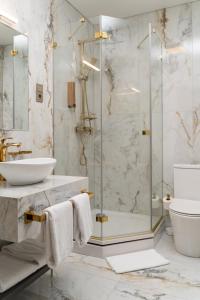维尔纽斯St Palace Hotel的一间带玻璃淋浴和水槽的浴室