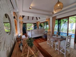 攀瓦海滩Soul Villas by The Beach - Phuket的客厅配有桌子和沙发