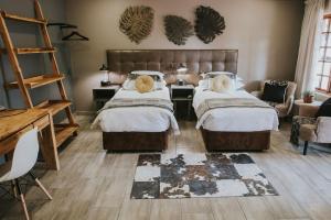 内尔斯普雷特Lowveld Living Guesthouse的一间卧室配有两张床、一张桌子和一张沙发
