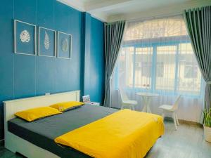 下龙湾La Casa Homestay - 11B Anh Đào, Bãi Cháy的一间卧室设有一张床和蓝色的墙壁