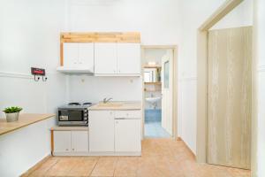 奥林匹亚达Evelyn Studios的厨房配有白色橱柜和微波炉