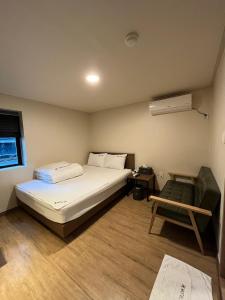 釜山Ssangma Motel的一间卧室配有一张床和一把椅子