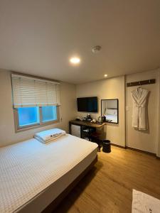 釜山Ssangma Motel的一间卧室配有一张床和一张桌子,墙上挂着衬衫