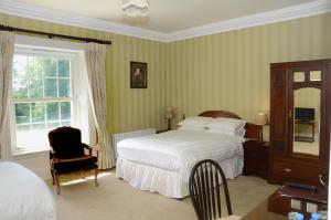 麦克鲁姆坎纳威之家住宿加早餐旅馆的卧室配有床、椅子和窗户。
