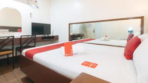 马尼拉RedDoorz @ Riches Holiday Hotel Avenida的酒店客房设有两张床和电视。