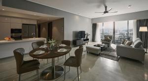 吉隆坡TRILLION SUITES by SLG的厨房以及带桌椅的起居室。