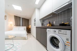 釜山Urbanstay Busan Cityhall的酒店客房配有一张床和一台洗衣机