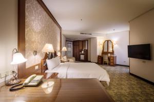 中坜承携行旅-中坜中正馆的酒店客房配有一张床、一张书桌和电话