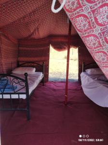BadīyahSandGlass Camp的小房间设有两张床和窗户