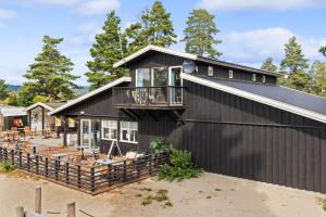 SvensrudTopcamp Onsakervika - Tyrifjorden的黑色的房子,上面设有阳台