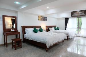 拜县Cha Li's Family Hotel&Hostel的一间卧室配有两张带绿色枕头的床