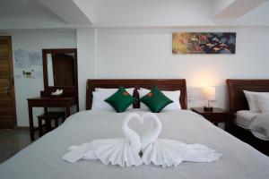 拜县Cha Li's Family Hotel&Hostel的卧室配有天鹅装饰,位于床上