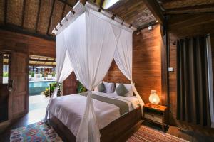 乌鲁瓦图Kayu Mama Resort and Spa的一间卧室配有一张带天蓬的床