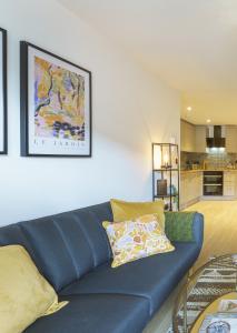 布里斯托Euphorbia - 1 Bedroom Luxury Apartment by Mint Stays的一间带蓝色沙发的客厅和一间厨房