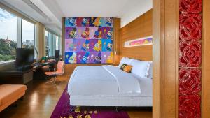 厦门厦门海港英迪格酒店的一间卧室配有一张床、一张书桌和一台电视