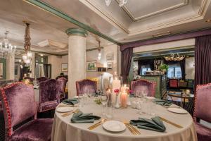 里加嘉逸豪庭酒店 - 立鼎世酒店集团的一间带桌子和紫色椅子的用餐室