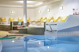 莱尔莫斯Loisach Smarthotel by keyone的一个带黄色椅子的游泳池