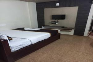 KurmannapalemBhimas Residency的一间酒店客房,配有一张床和一台电视