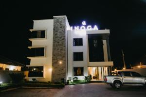 多多马Inoga Luxury Hotel的夜间停在大楼前的汽车
