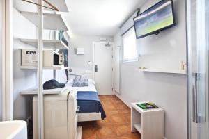 伊维萨镇Ryans Pocket的小房间设有一张床和一台平面电视