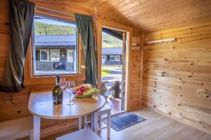 莫舍恩Topcamp Mosjøen - Helgeland的小木屋内带桌子和窗户的用餐室