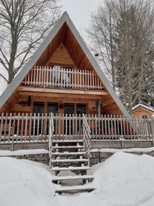 毛特Wildkräuter Hexenhaus的雪地小木屋,带白色围栏