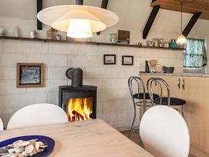 博恩瑟6 person holiday home in Bogense的一间带壁炉和桌椅的用餐室