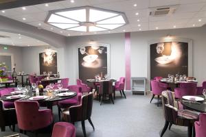 蒙莫里永Logis Hôtel de France restaurant le Lucullus的一间带桌子和紫色椅子的用餐室