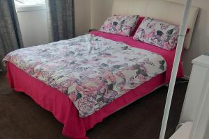 NoarlungaCascabelbnb Private 2BR apartment的一张带粉色和白色棉被及枕头的床