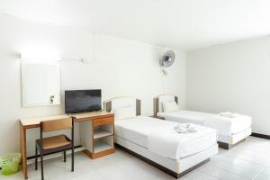 合艾Boonchai Mansion的客房设有两张床、一张桌子和一台电视机。