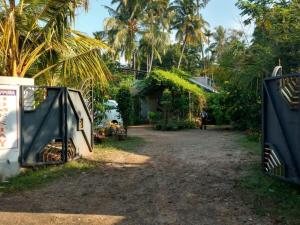 阿勒皮Kalappura Homestay的通往带房子和棕榈树的院子的大门