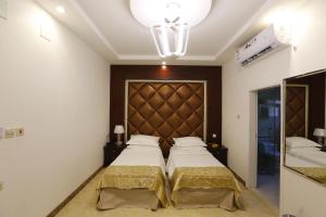 Taymāʼفندق حصن الأبلق - Alablaq Hotel的一间带两张床和大床头的卧室