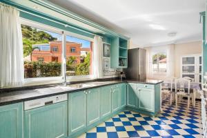 拉克鲁斯Villa Artigar, garden, swimming pool and bbq.的厨房配有蓝色橱柜和 ⁇ 格地板