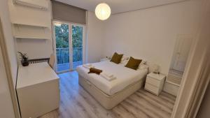 马德里Espectacular apartamento en Cuzco / Alberto Alcocer的一间小卧室,配有白色的床和窗户