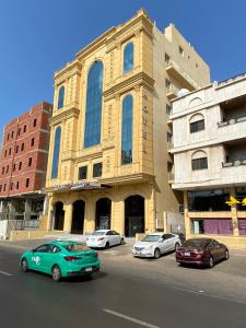 吉达Golden New Quraish Jeddah的停在大楼前的一组汽车