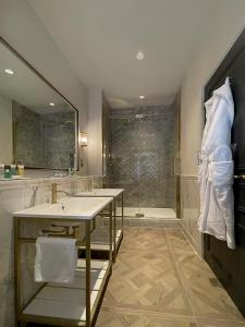 米尔顿凯恩斯Horwood House Hotel的带淋浴、盥洗盆和浴缸的浴室