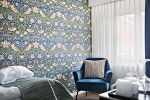 韦斯特维克韦斯特维克贝斯特韦斯特普勒斯城市酒店的一间卧室配有蓝色椅子和花卉壁纸