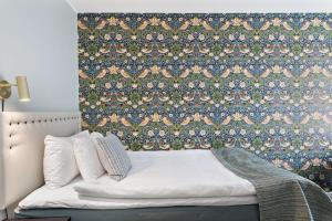 韦斯特维克韦斯特维克贝斯特韦斯特普勒斯城市酒店的一间卧室配有一张带花卉壁纸的床