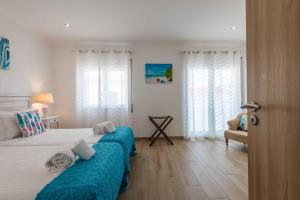 阿尔布费拉Casa Mar d'Alma的一间卧室配有一张带蓝色床单的床和一把椅子