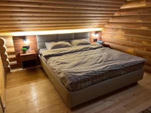 斯基希德尼萨Cottage Forest House的木墙客房的一张床位