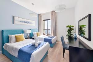 迪拜Luxury JBR Shams - Sea or Marina View - Free 5 star Beach Resorts Access!的一间酒店客房,设有两张床和电视