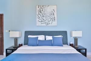 迪拜Luxury JBR Shams - Sea or Marina View - Free 5 star Beach Resorts Access!的一间蓝色卧室,配有一张床和两盏灯