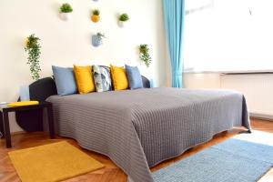 布拉格Old Town Konviktská - Bohemian Residence的一间卧室配有黄色和蓝色枕头的床