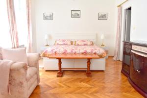 布拉格Old Town Konviktská - Bohemian Residence的一间卧室配有一张床、一张沙发和一台电视。