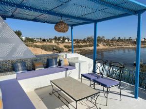 DjerbaDar Elbidha的一个带桌椅的庭院,享有水景