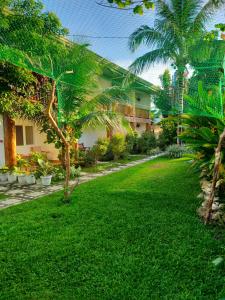 邦劳Hotel Renate的一座种植了棕榈树的绿色庭院和一座建筑