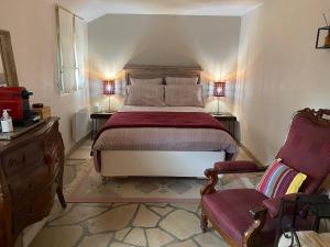 CrothLe Chemin du Village的一间卧室配有一张大床和两把椅子